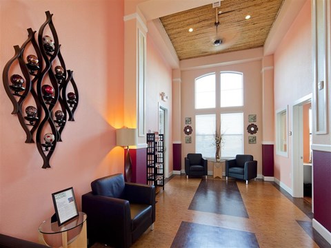 A living room with a black couch and a wooden table.