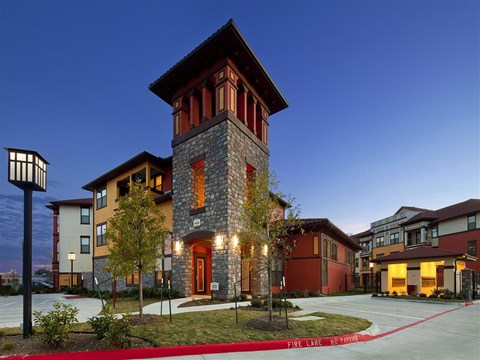 A building with a red and brown facade and a tower with a red roof.
