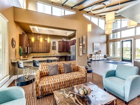 A living room with a patterned sofa and a coffee table with a bowl of fruit on it.