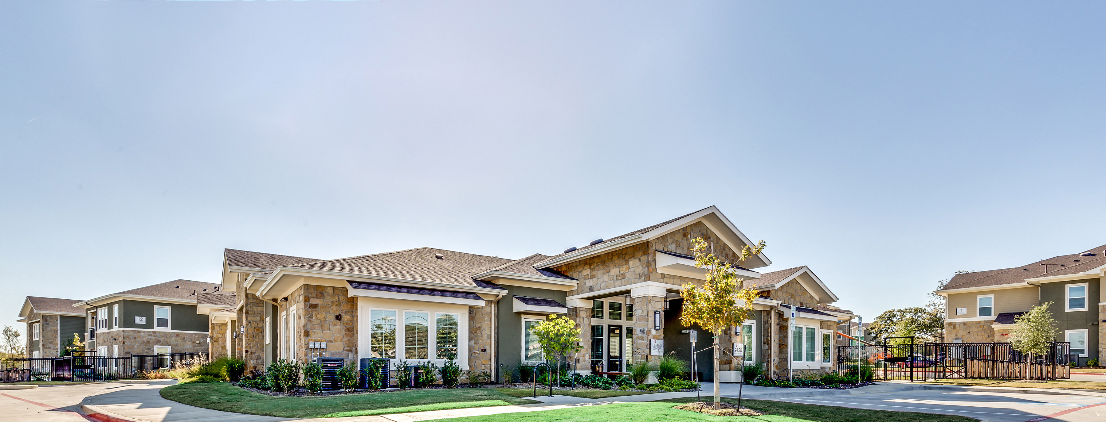 A row of houses with a clear blue sky above them.