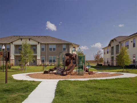 Community playground featuring modern play equipment, slides, and a welcoming outdoor space for recreation and exploration.