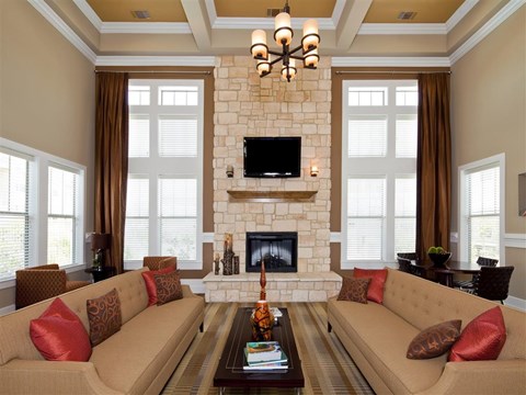 A living room with a fireplace and a television mounted above it.