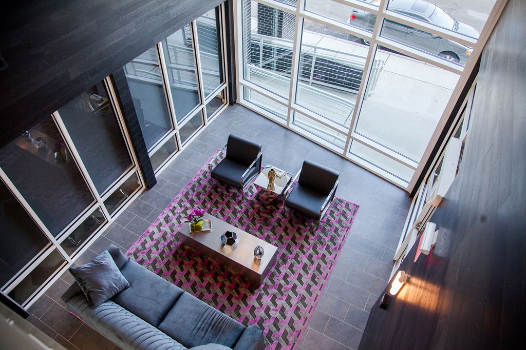 a living room with a couch and two chairs on a rug