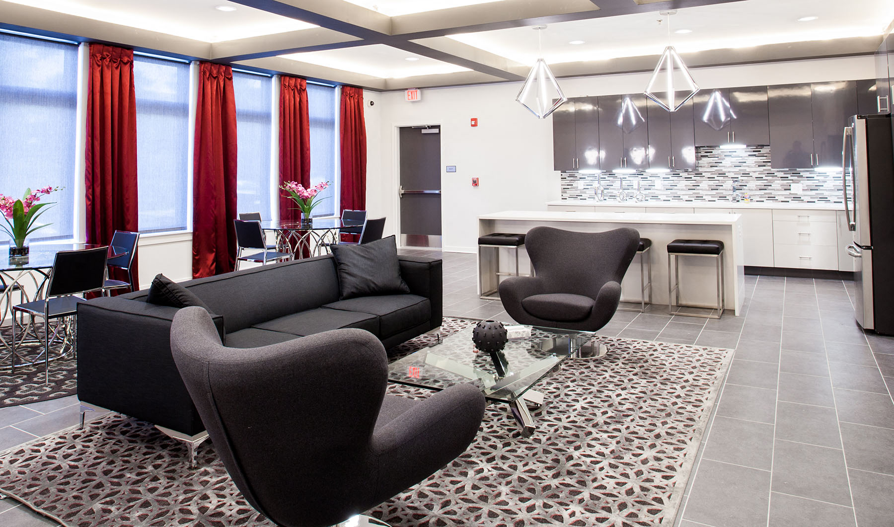 a living room with couches and chairs and a kitchen