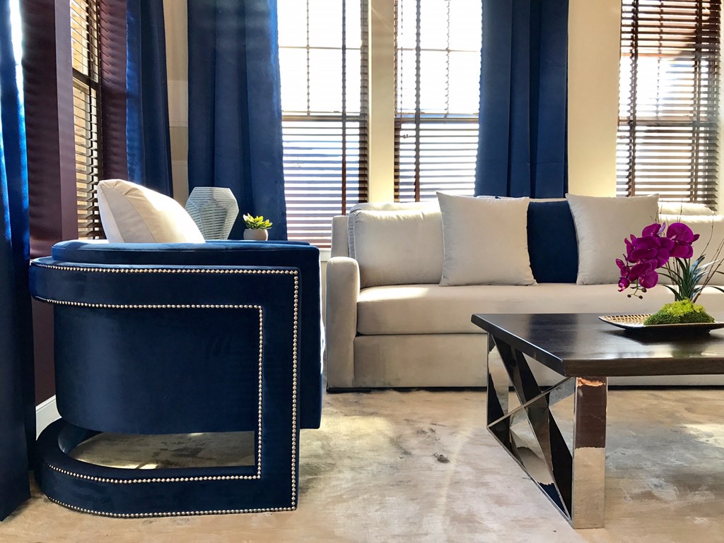 a living room with blue curtains and a white couch and a coffee table