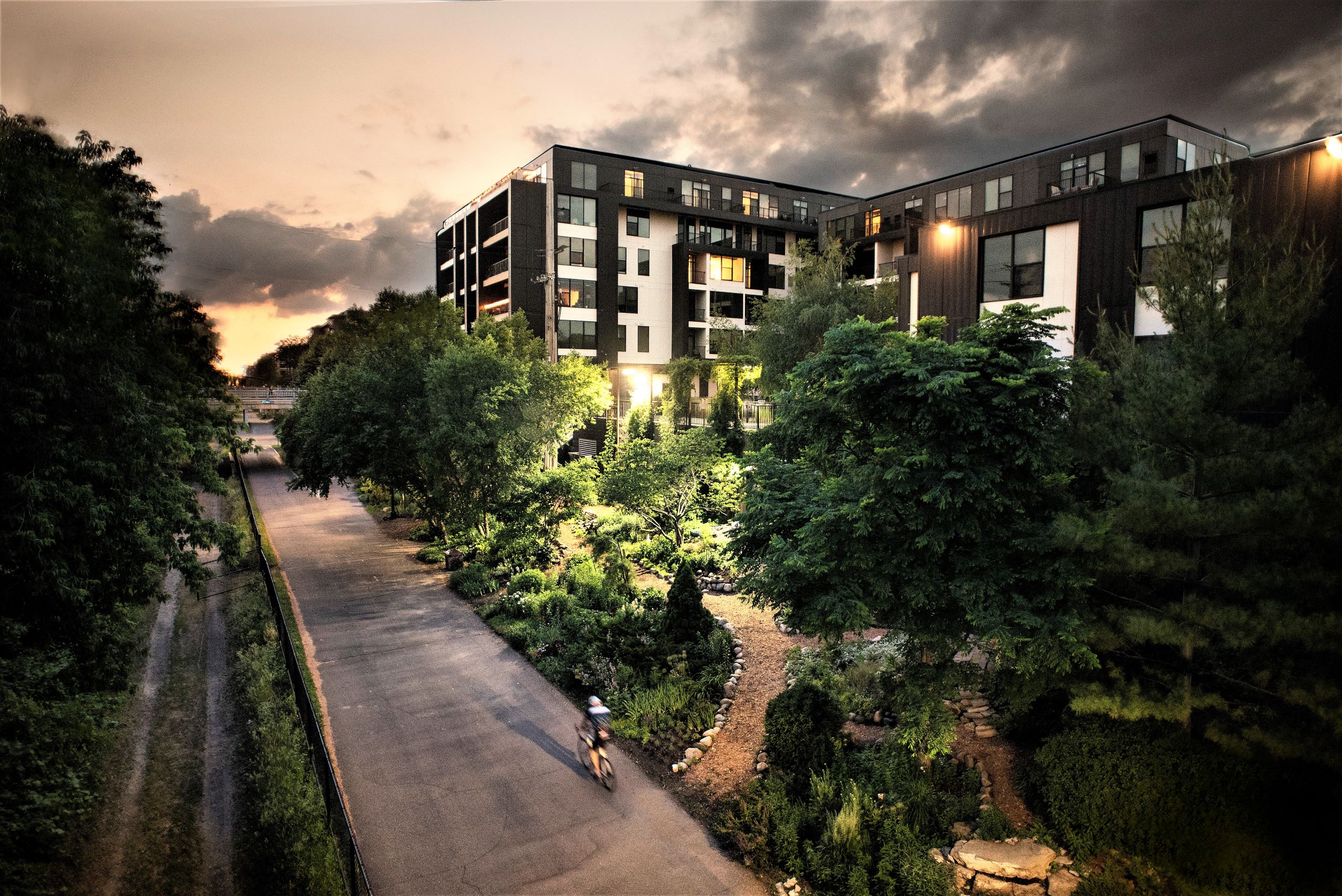 a person riding a bike down a street next to a building