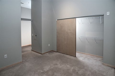 a bedroom with a closet and a mirrored closet door