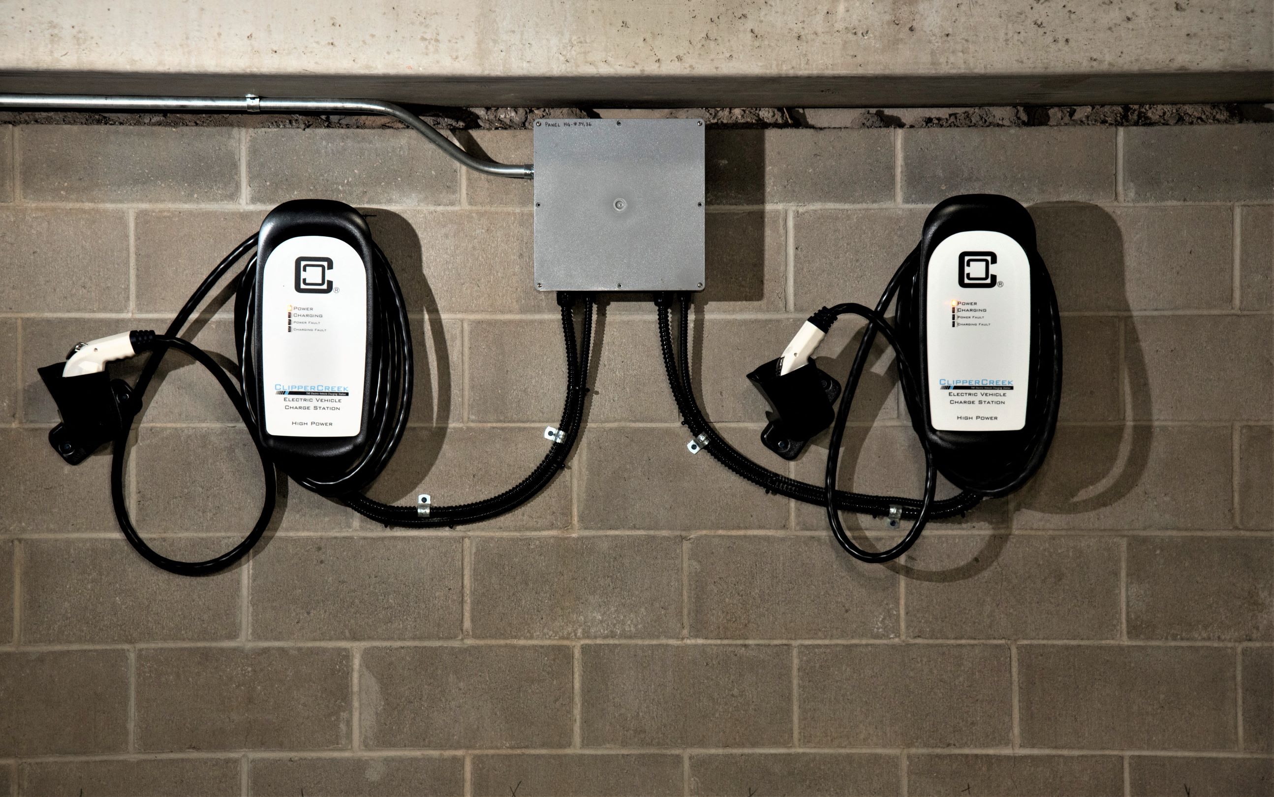 a row of charging cords on a brick wall