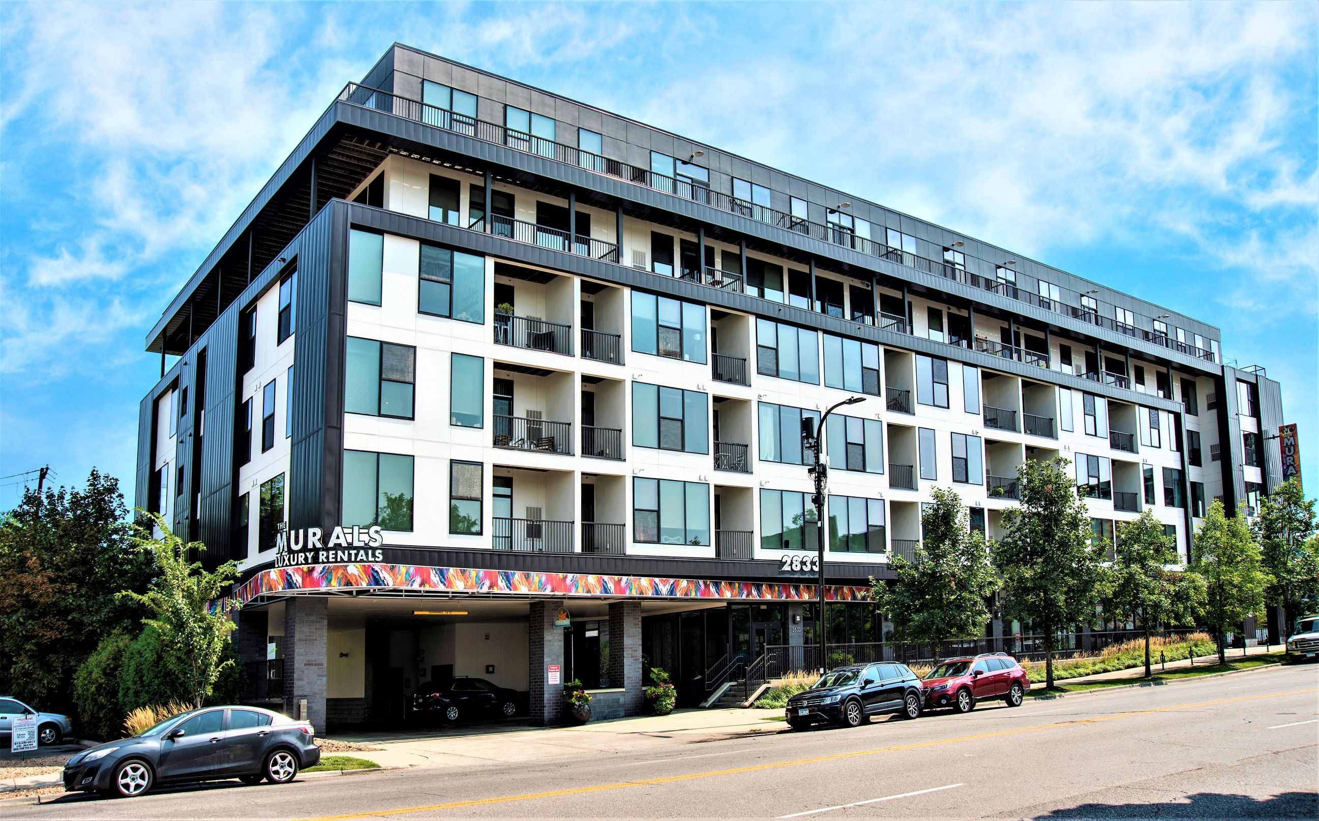a large building with cars parked in front of it on a street