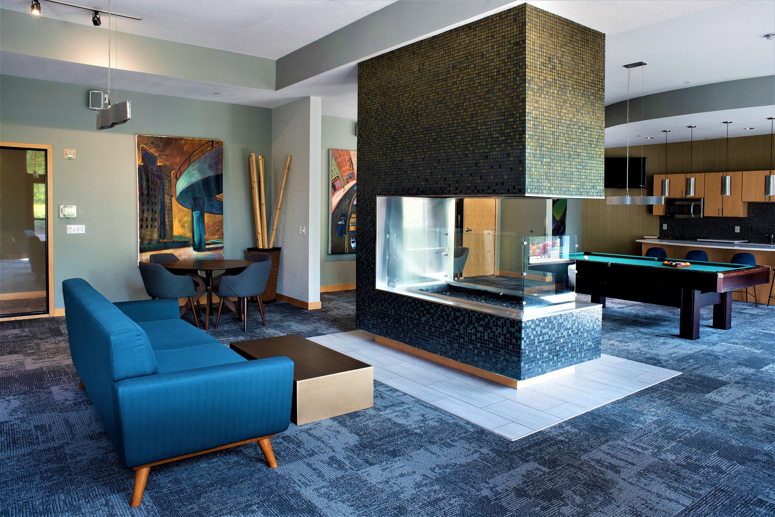 a living room with a pool table and a blue couch