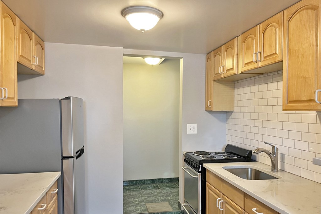 A kitchen with wooden cabinets and a white refrigerator.
