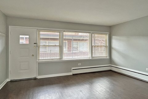 A room with a white door and a window with blinds.