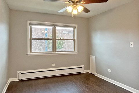 A room with a window and a ceiling fan.