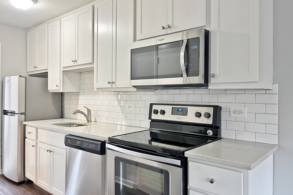 A kitchen with a stove, oven, dishwasher, and refrigerator.