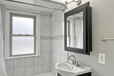 A bathroom with a white sink and a window.