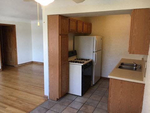 an empty kitchen with a refrigerator and a sink