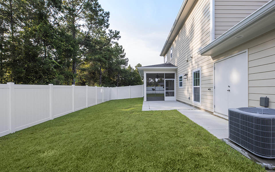 a backyard with a patio and a white fence