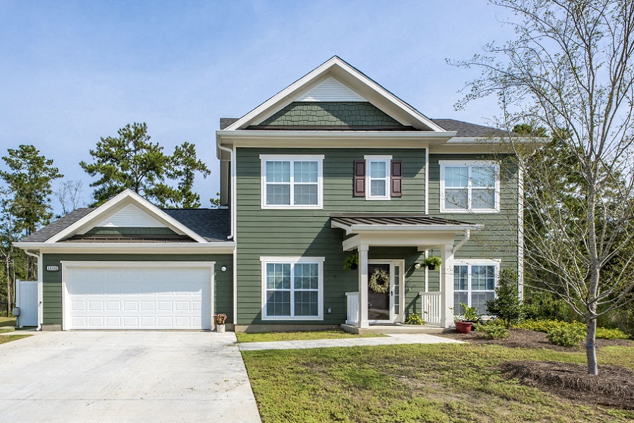 a green house with a white garage door