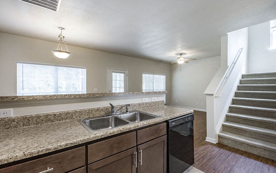 an empty kitchen with a sink and a staircase