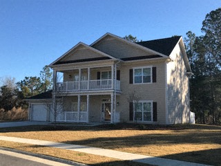 a white house with a balcony on the side of a street