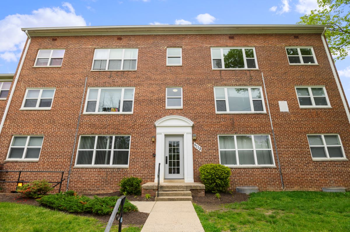 the front of a brick building with a white door