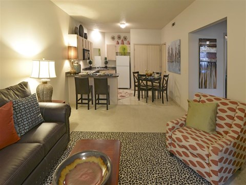 a living room and kitchen with a couch and a table