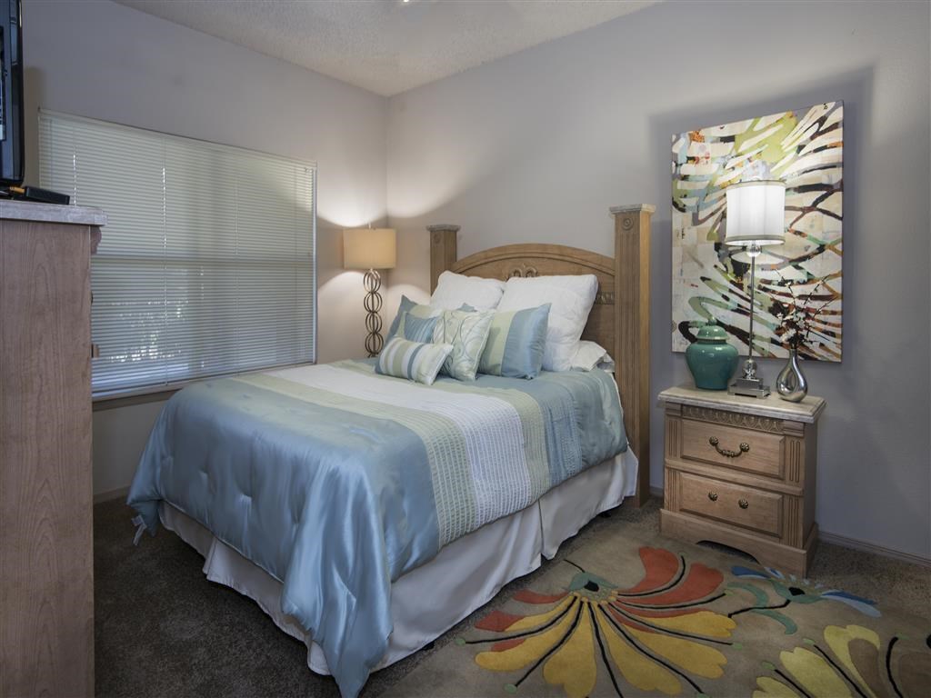 a bedroom with a bed and a painting on the wall