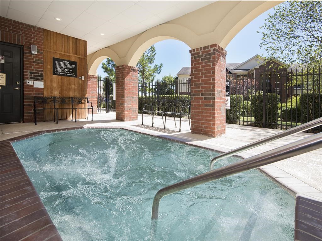 a hot tub in a pool in a building with a fence