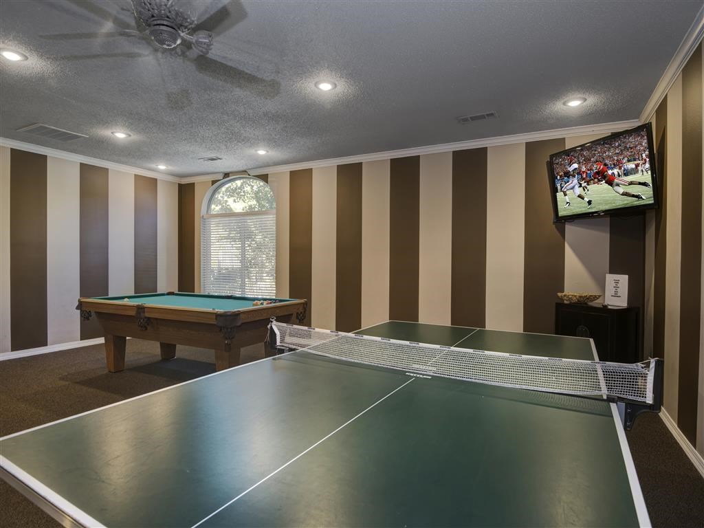 a game room with a pool table and a tv