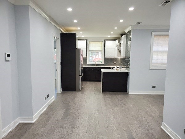 an empty kitchen with a sink and a refrigerator