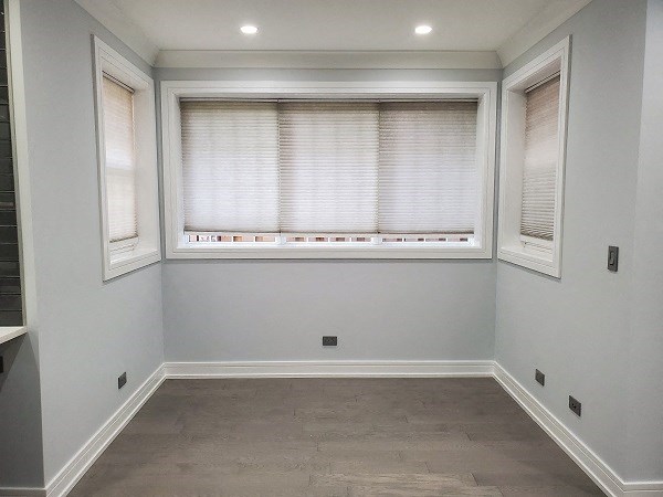 an empty room with a large window and blinds