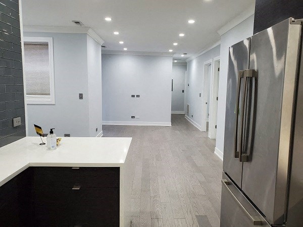 a white kitchen with a stainless steel refrigerator
