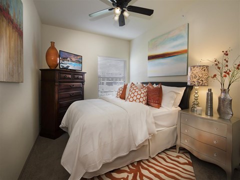 a bedroom with a bed and a ceiling fan
