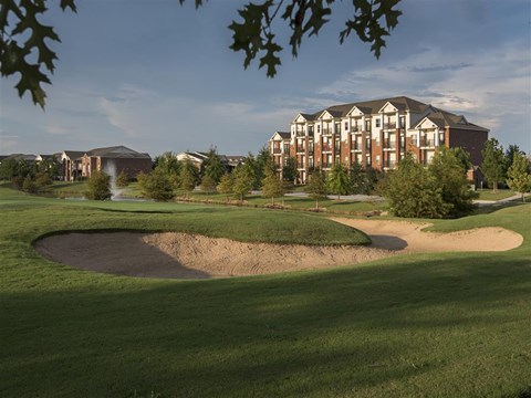 a golf course with an apartment building in the background