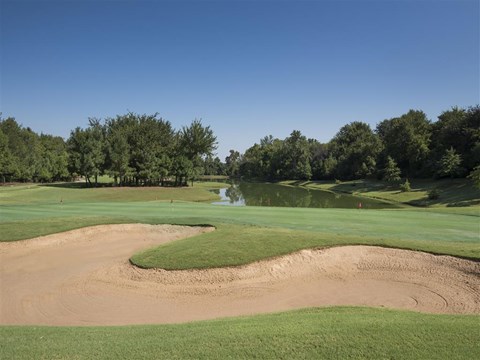 a golf course with a pond and a green