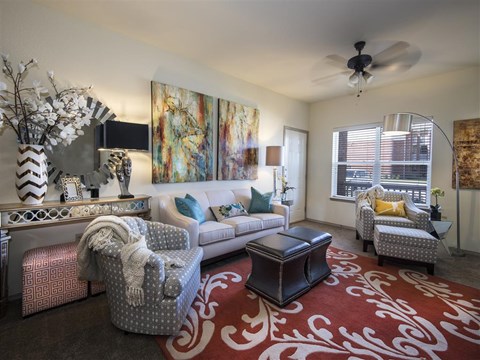 a living room with furniture and a ceiling fan