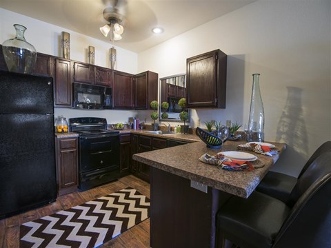 a kitchen with black appliances and a granite counter top
