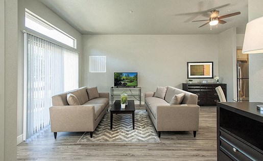 Pet-Friendly Apartments In Davis - Octave Apartments - Renovated Living Room With Ceiling Fan, Wood-Style Flooring, And Access To Patio Or Balcony.