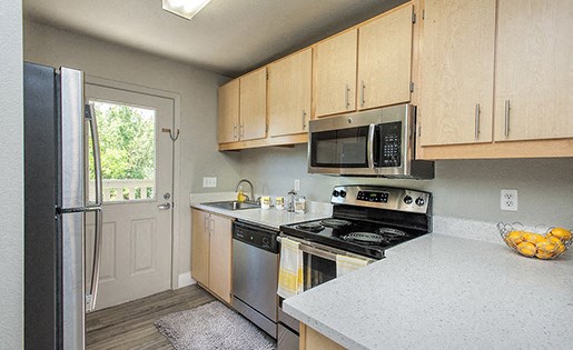 Davis, CA Apartments - Octave Apartments - Kitchen With Stainless Steel Appliances, Quartz Countertops, Wood-Style Flooring, Wood-Style Cabinets, Dishwasher, And Access To Outside Area.