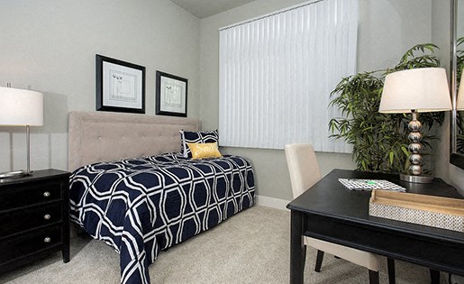 1, 2, & 3-BR Apartments In Davis, CA - Octave Apartments - Roomy Bedroom With Plush Carpet Flooring And A Window With Blinds.