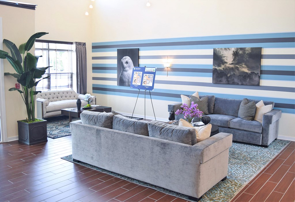 a living room with blue and white striped walls and a gray couch