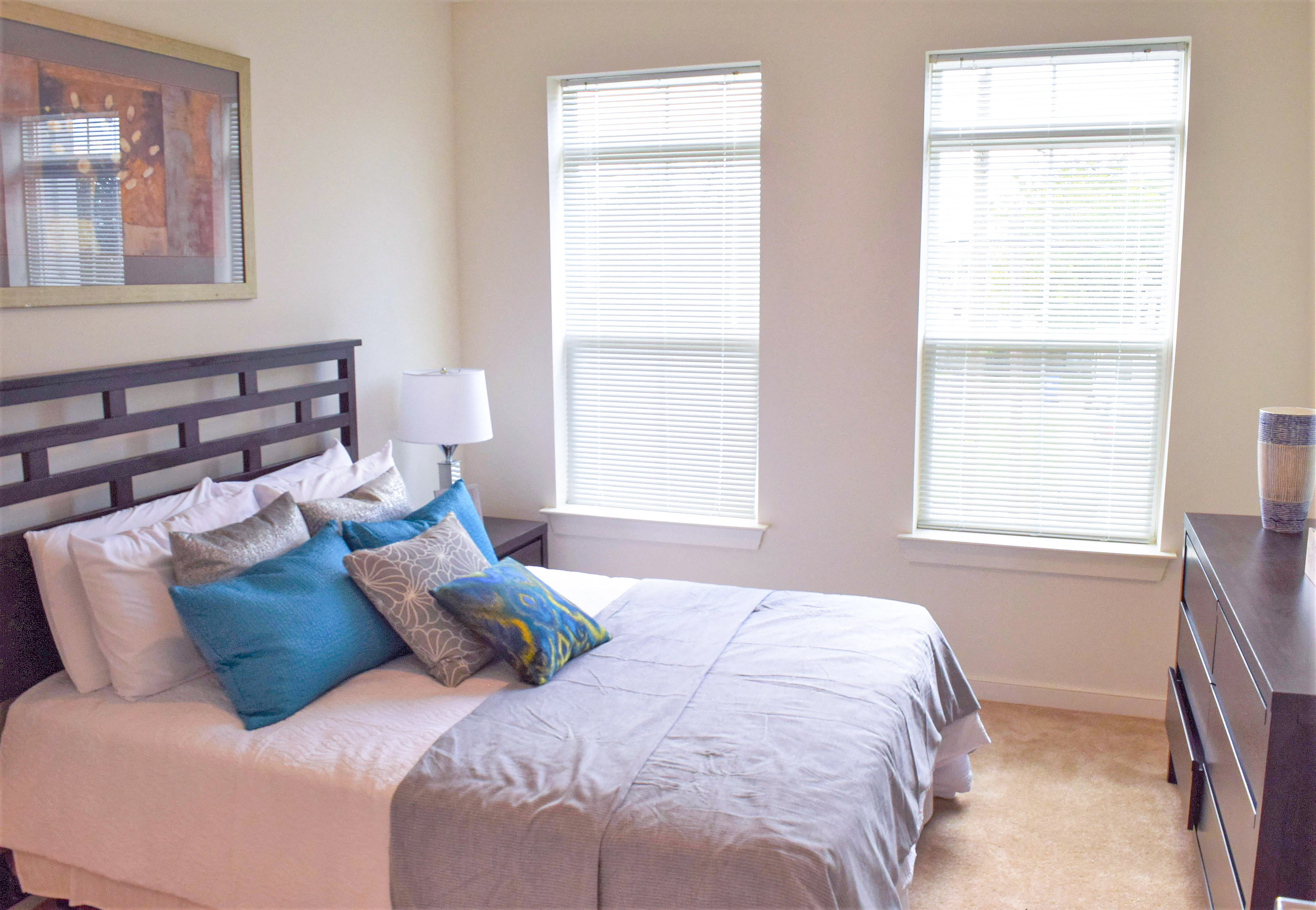 a bedroom with a bed and two windows