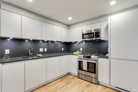 a kitchen with white cabinets and stainless steel appliances