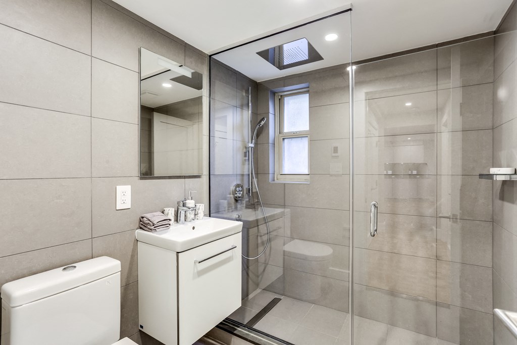 a bathroom with a shower and a sink and a toilet