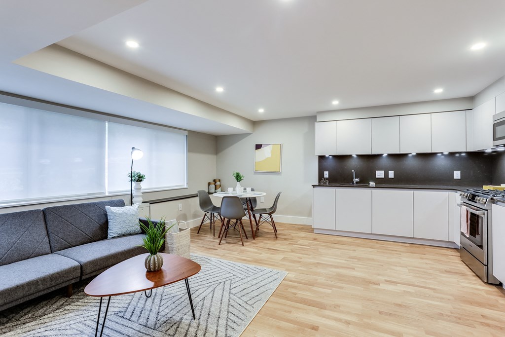 a living room with a couch and a table and a kitchen