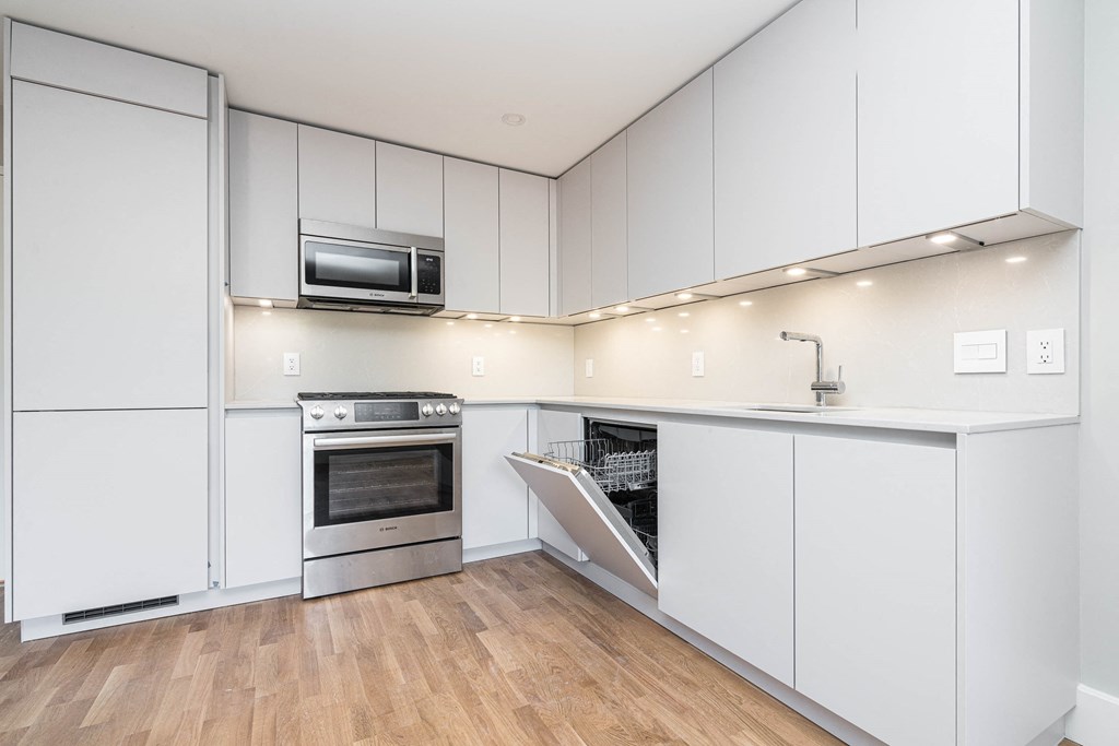 a kitchen with white cabinets and stainless steel appliances