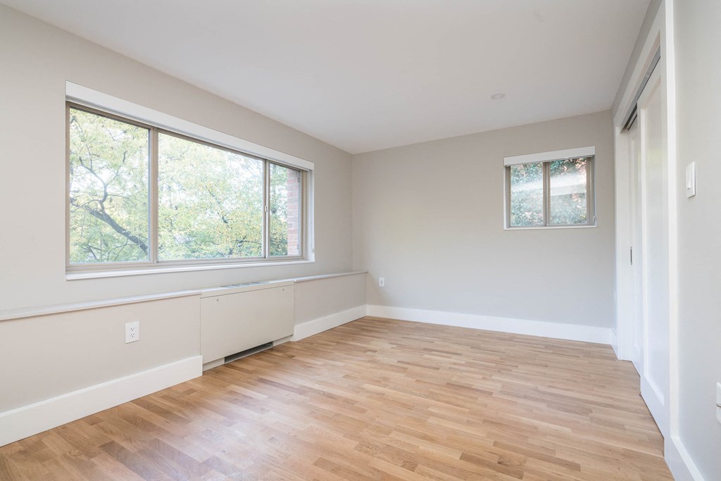 a living room with a hardwood floor and large windows