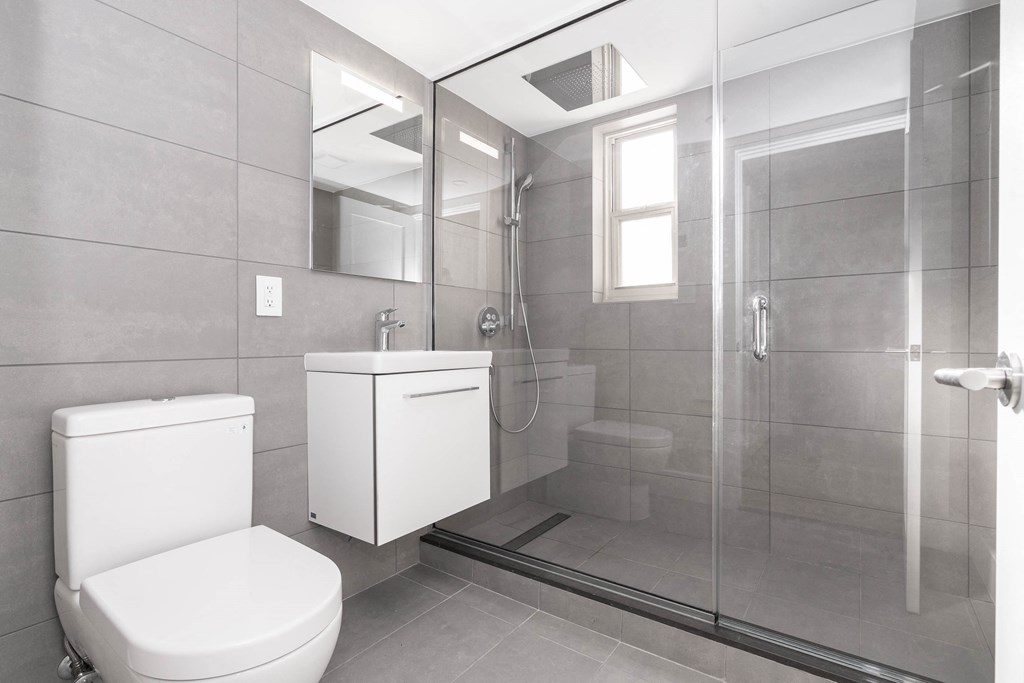 a white bathroom with a shower toilet and sink