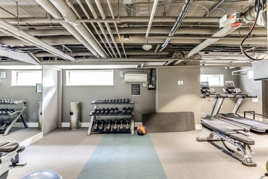 a workout room with weights and cardio equipment