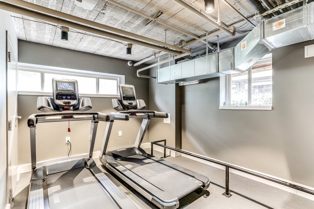 two treadmills and a treadmill in the gym of an apartment building